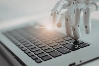 Mão robótica digitando em um teclado de computador