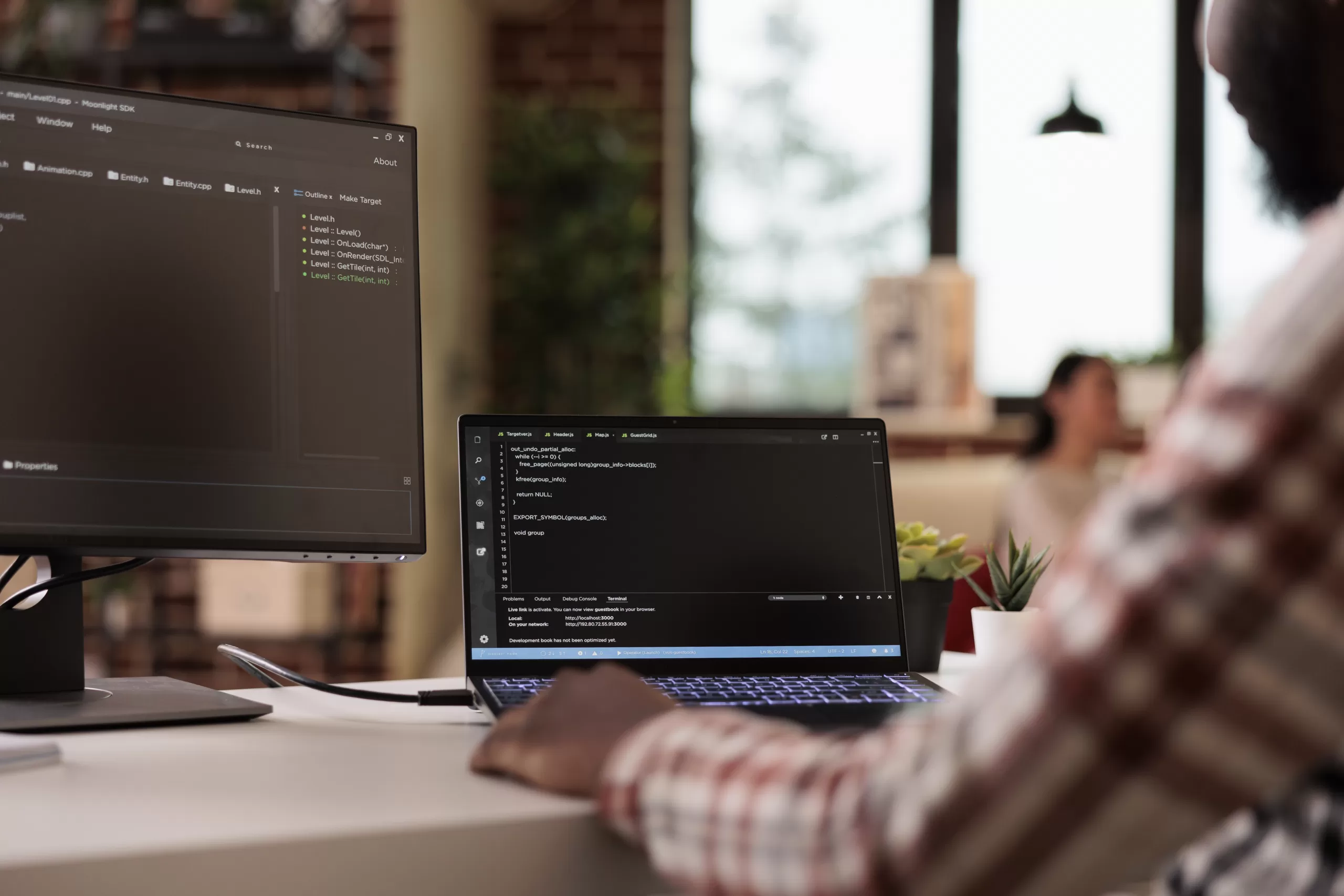 Desenvolvedor trabalhando em um ambiente com múltiplos monitores exibindo código em editor de texto, representando o desenvolvimento e manutenção de software.